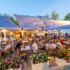 Ristorante all'aperto con persone sedute.