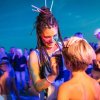Una donna dipinge il viso di un bambino durante un evento serale all'aperto.